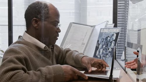 Bank Teller Helping Elderly African American Customer with Documents