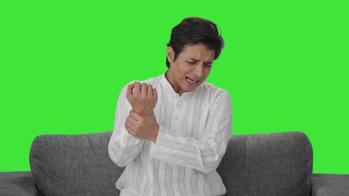 Sick Indian man having hand pain Green screen