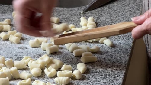 Gnocchi mit den Händen auf einem Gnocchi-Brett — Nahaufnahme