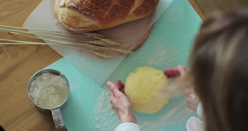 Woman Kneading Bread Dough at Wooden Table