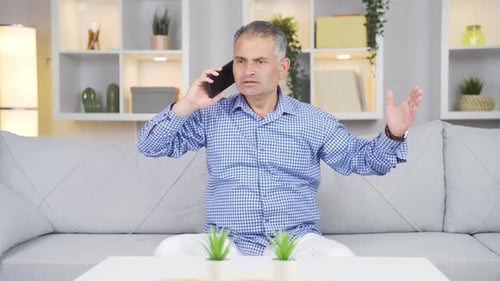 Hombre hablando por teléfono discutiendo.