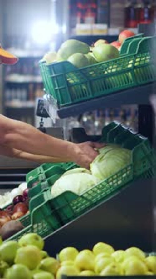 Asian Chinese Seller Workman Organizing Vegetables on Grocery Shelves Wearing Black Mask Against