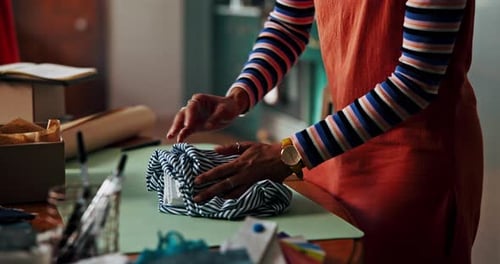 Small business, hands and packing clothes for online order with retail fashion supplier
