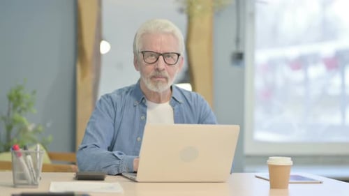 Senior Man Working on Laptop in Office