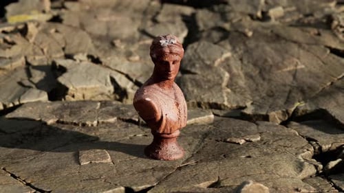 Ancienne statue de femme sur des pierres rocheuses