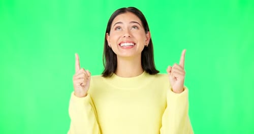 Happy, woman and face on green screen pointing up to mockup background, studio and smile