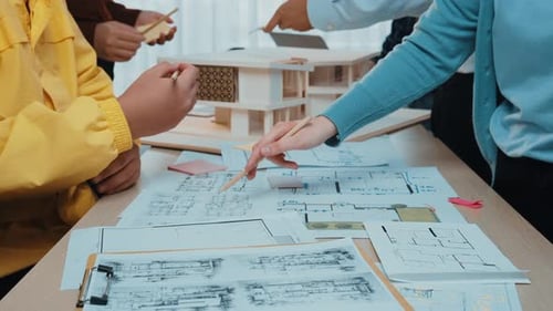 Team Discussing Architectural Blueprints and Model