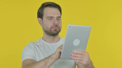 Man Interacts with Tablet on Yellow Background