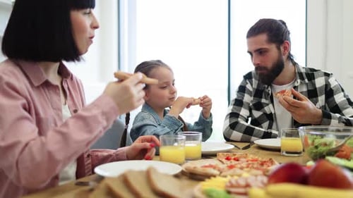 Family Enjoys Pizza Dinner Together at Home