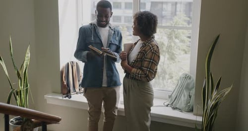 High School Students African American People Standing in Lobby Talking Holding Book
