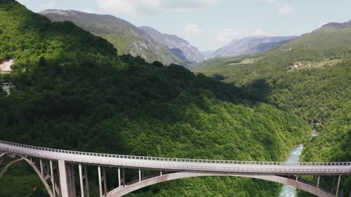 Dramatic Aerial View Of Massive Arch Bridge Over Deep Canyon