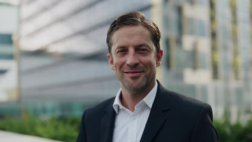 Portrait of Successful Businessman Smiles Looking at Camera on Downtown Street