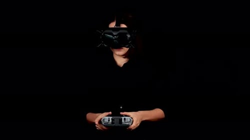 Young Woman With VR Goggles and Remote Controller Playing Video Game in Virtual Reality