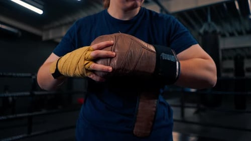 Boxer Putting On Boxing Gloves in the Gym