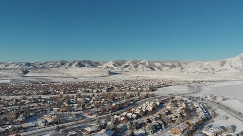A drone pan over Lakewood Colorado, Red Rock in the distance.