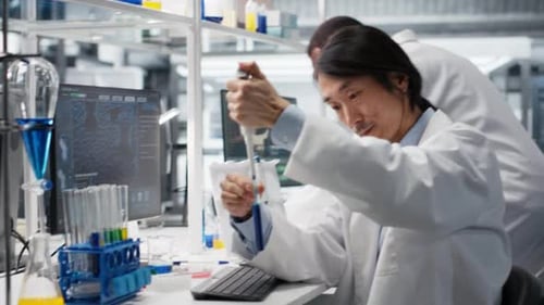 Scientist Using Pipette Mixing Chemicals in Laboratory