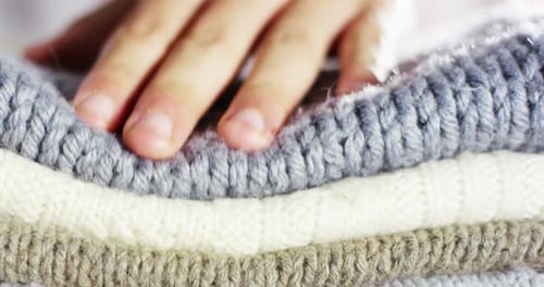 Close-up of Cozy Knitted Sweaters with Gentle Hand