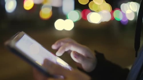 Man Touching Screen on Tablet at Night on the Street Closeup