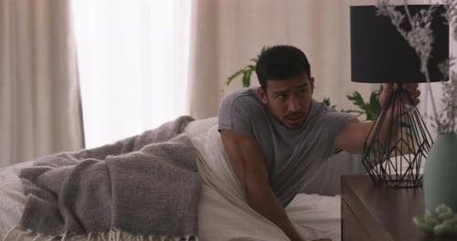 Man Waking Up Sad in Bed in Morning