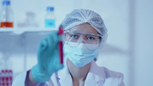 Female scientist working on microscope on cells and bacteria in laboratory for research