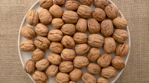 Vista aérea de un plato lleno de nueces sin cáscara que gira sobre una arpillera