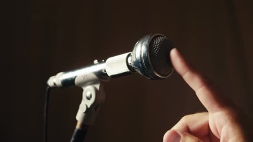 Retro Microphone on Studio or Stage Macro of Check Sound Hand Touch Microphone