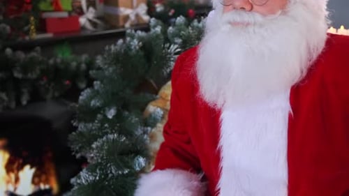 Santa Claus Sitting Next to a Christmas Tree