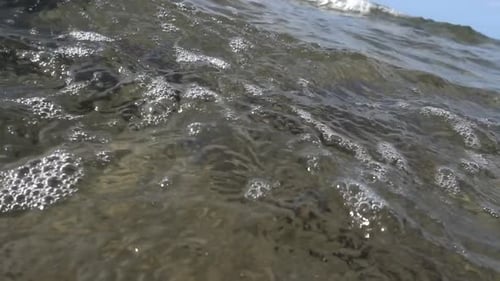 Low viewpoint of small waves coming to shore. Mediterranean Sea. Sicily. Italy