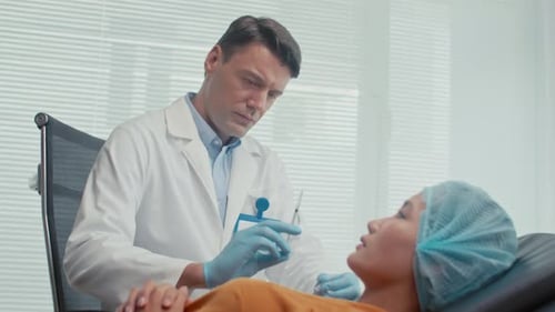 Arzt injiziert einer Kundin eine Verjüngungsbehandlung in die Wangen