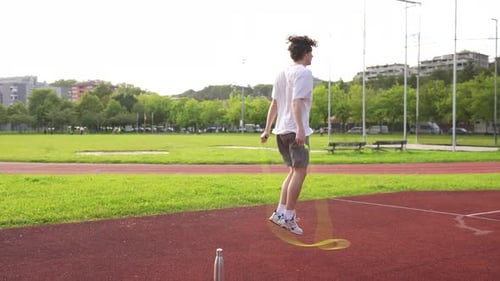 Young Adult Jumps Rope on Running Track