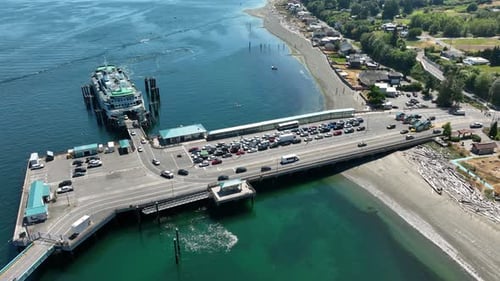 Aerial shot of vehicles leaving a docked ferry.