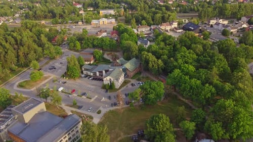 Aerial, flying above quiet Sigulda town, green vivid trees and architecture