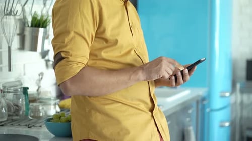 Man Using Mobile Phone in Modern Kitchen