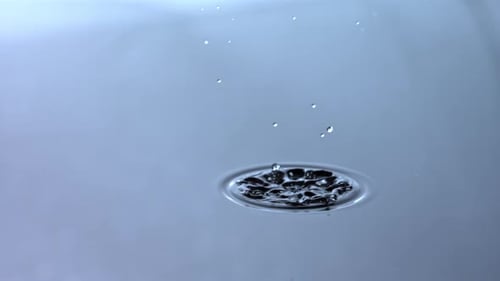 Water Drop Creating Ripples and Crown on Blue