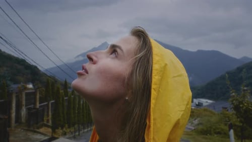Woman in Yellow Rain Jacket Looking Upward