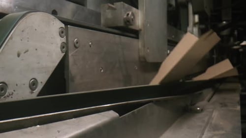 La máquina automática dobla cajas de cartón en el taller
