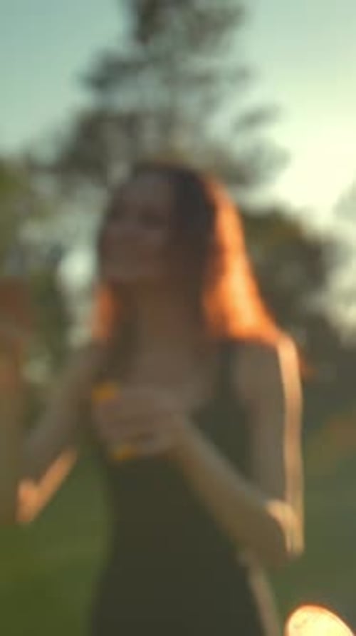 Vertical of Portrait of Beautiful Ginger Young Woman Blowing Bubble in the Park