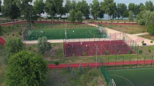 People Training on Openair Football and Basketball Courts in the Park