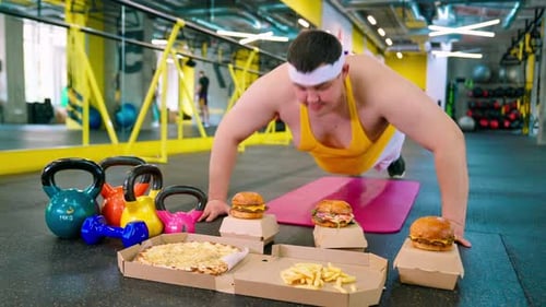 Man Doing Pushups with Fast Food in Gym