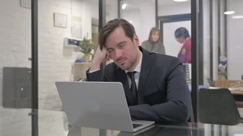 Müder Geschäftsmann mittleren Alters schläft bei der Arbeit