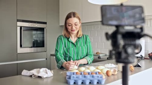 Woman Kneading Dough While Filming in Kitchen