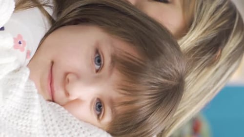 Loving Mother and Child Snuggling in a Bedroom