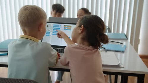 Kinder lernen während des Computergruppenunterrichts in der Schule auf dem Laptop zu programmieren
