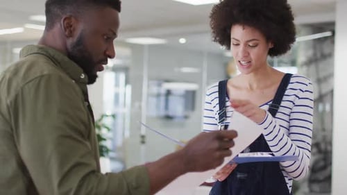 Zwei männliche und weibliche afroamerikanische Kollegen führen ein Geschäftsgespräch im Büro