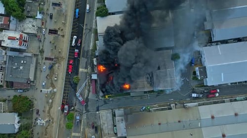 Une partie noire et sombre d'un bâtiment en feu s'élevant dans le ciel. Incendie dans un entrepôt après l'explosion d'une fuite de gaz. Aer