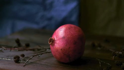 Roter Saft-Granatapfel auf Holzuntergrund. Frischer Granatapfel auf dunklem Holztisch