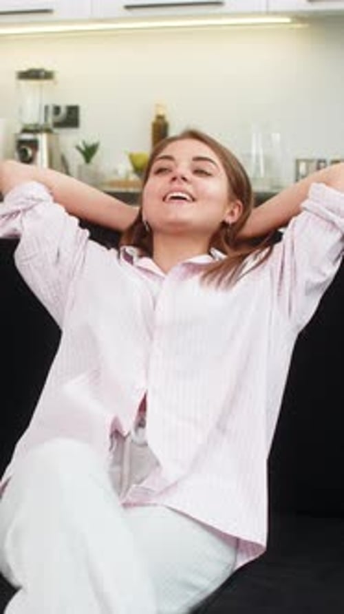 Relaxed Woman Leans Back on Couch Indoors