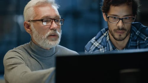 Le
designer créatif en chef montre l'écran d'un ordinateur de bureau à un jeune développeur, qui discute du projet.
T
