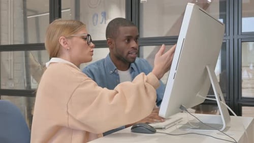 Interracial Couple Working on Computer in Office
