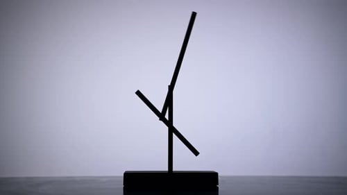 Magnetic Pendulum Balancing on White Background